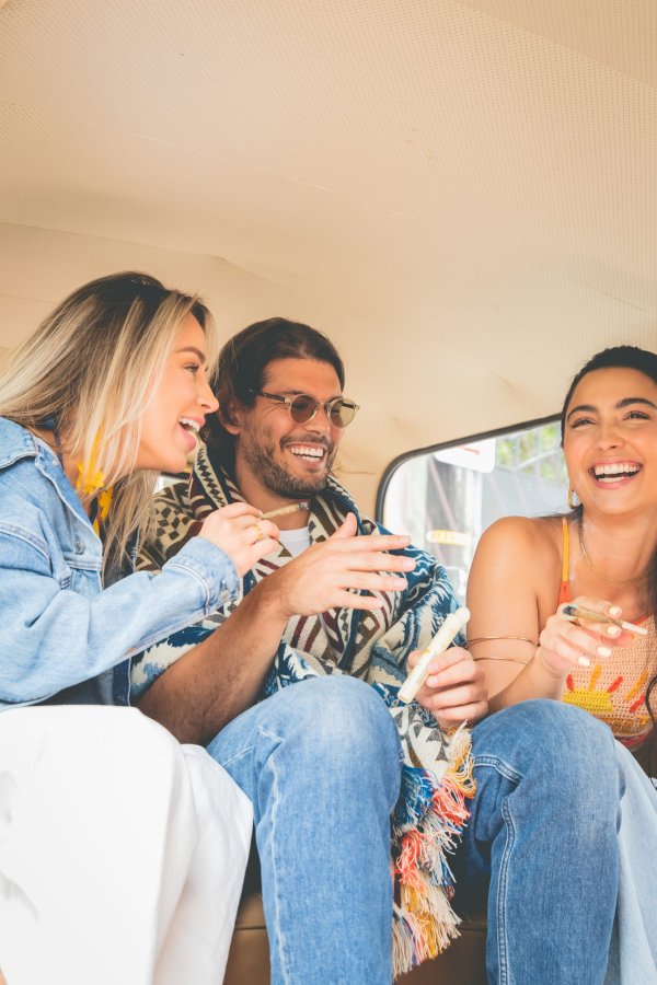 Happy girls and boy smoke in the car